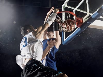 Two basketball players in action in gym